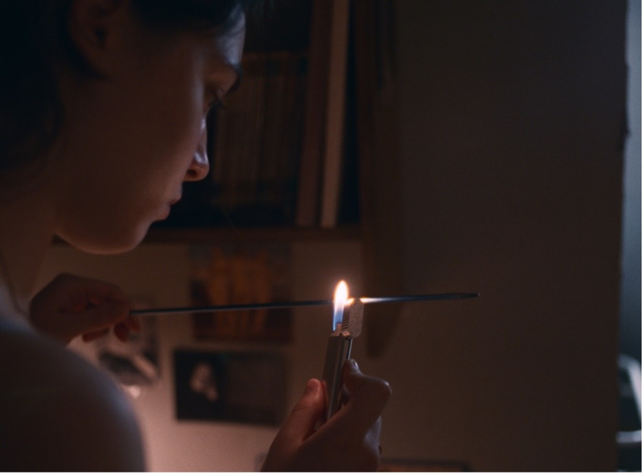 This image is of the main protagonist, who is sterilizing a knitting needle with a lighter.